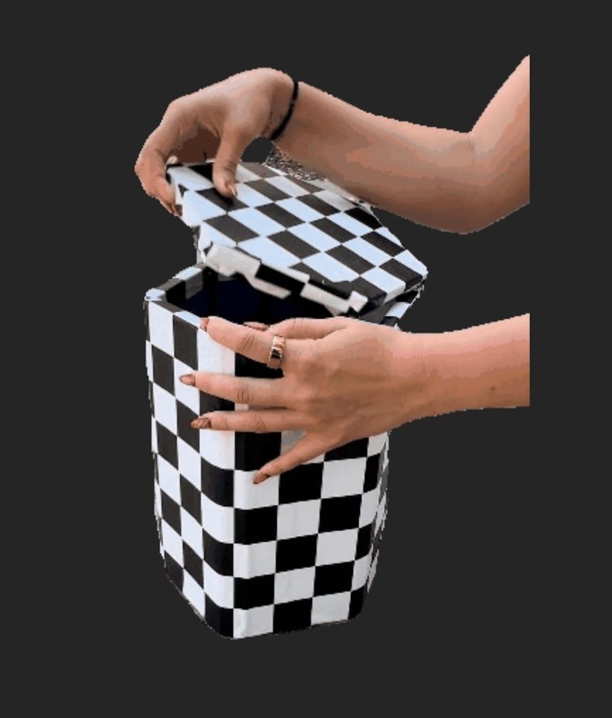 Hands opening the checkerboard-wrapped collapsible Street Seat, lid lifting off