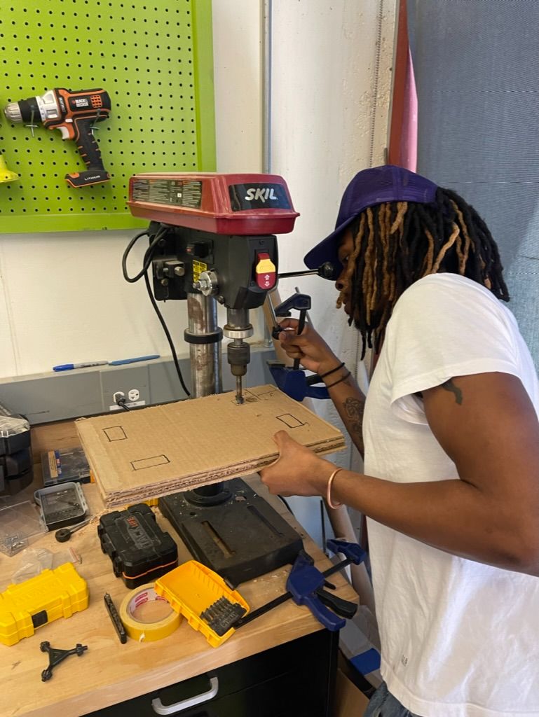 Drilling holes through a cardboard panel on a SKIL drill press
